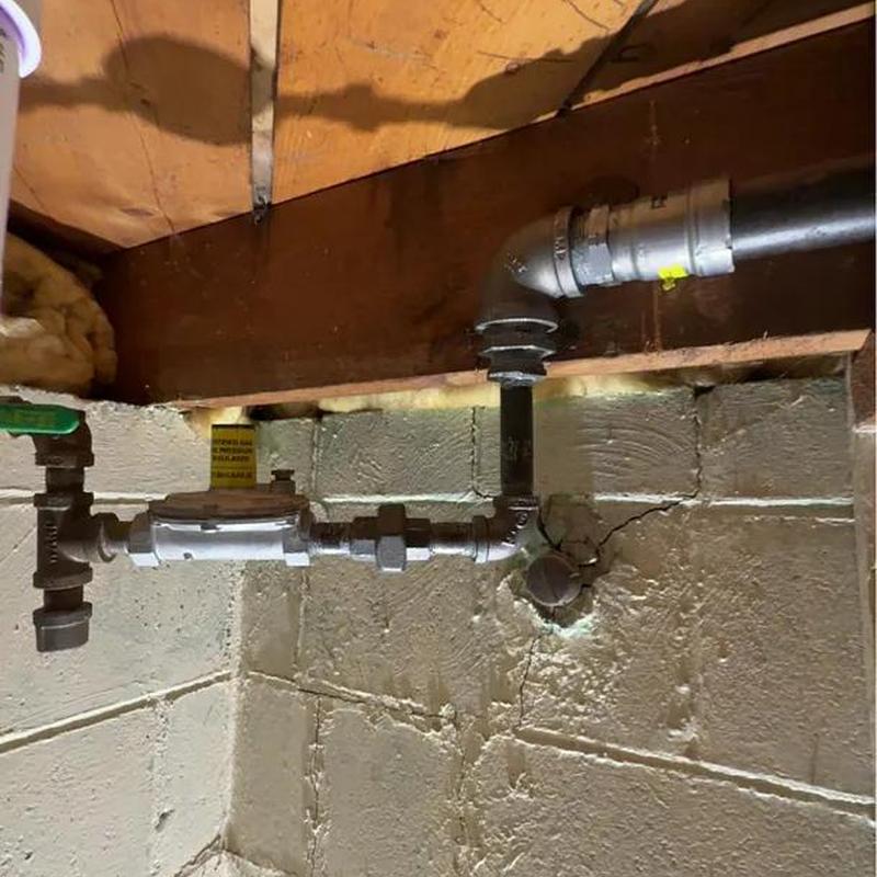 Gas line with shutoff valve and meter in basement wall
