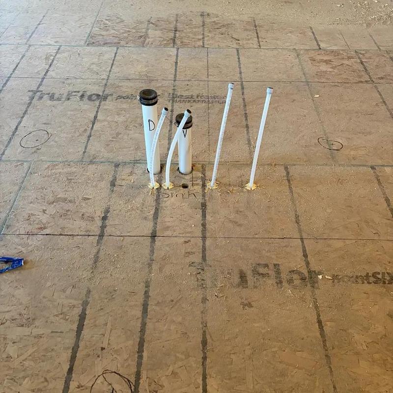 Sink plumbing rough-in pipes on subfloor