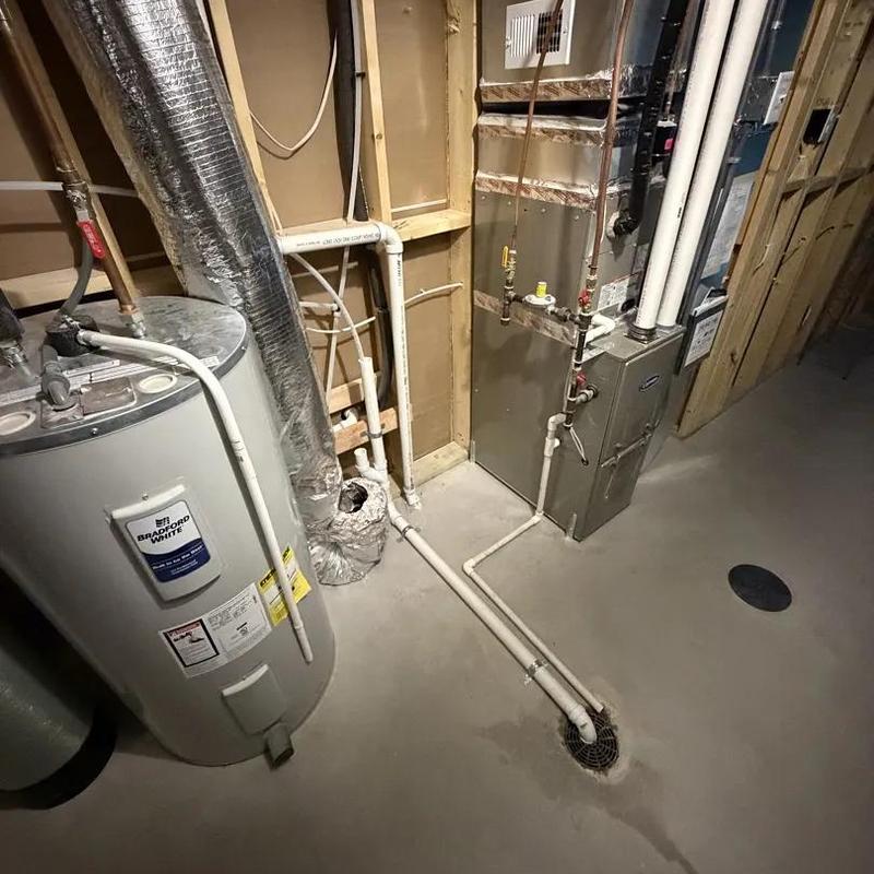 Water heater with adjacent furnace and piping in basement