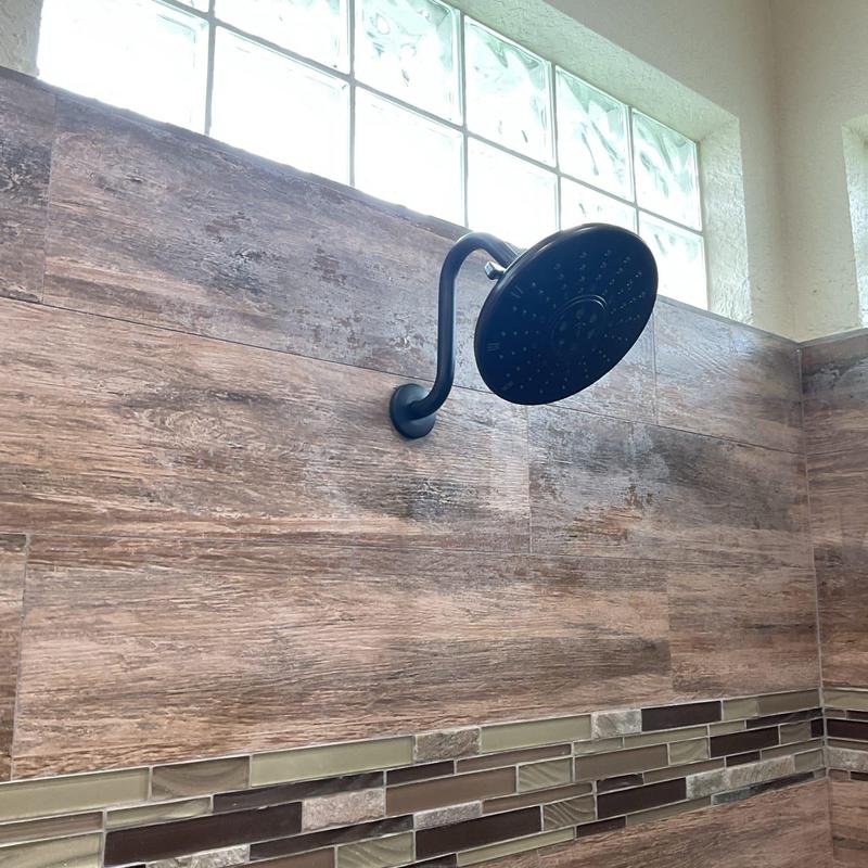 Shower head with black finish on tiled wall
