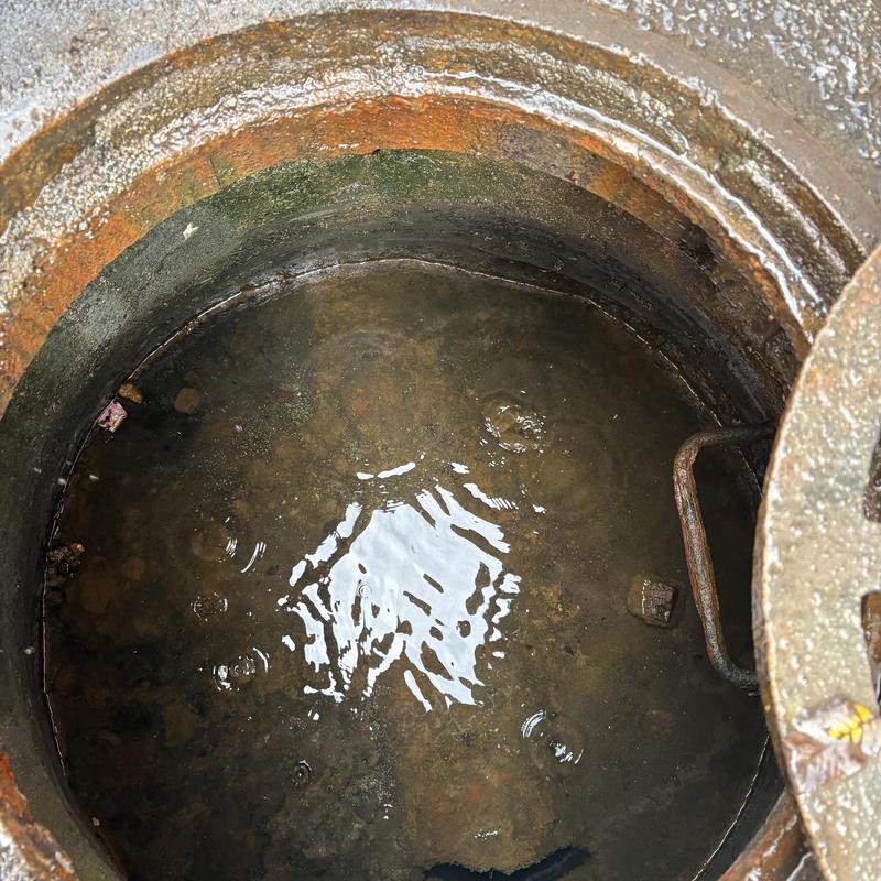 Storm drain manhole with standing water and rusted edge Storm drain manhole with standing water and rusted edge
