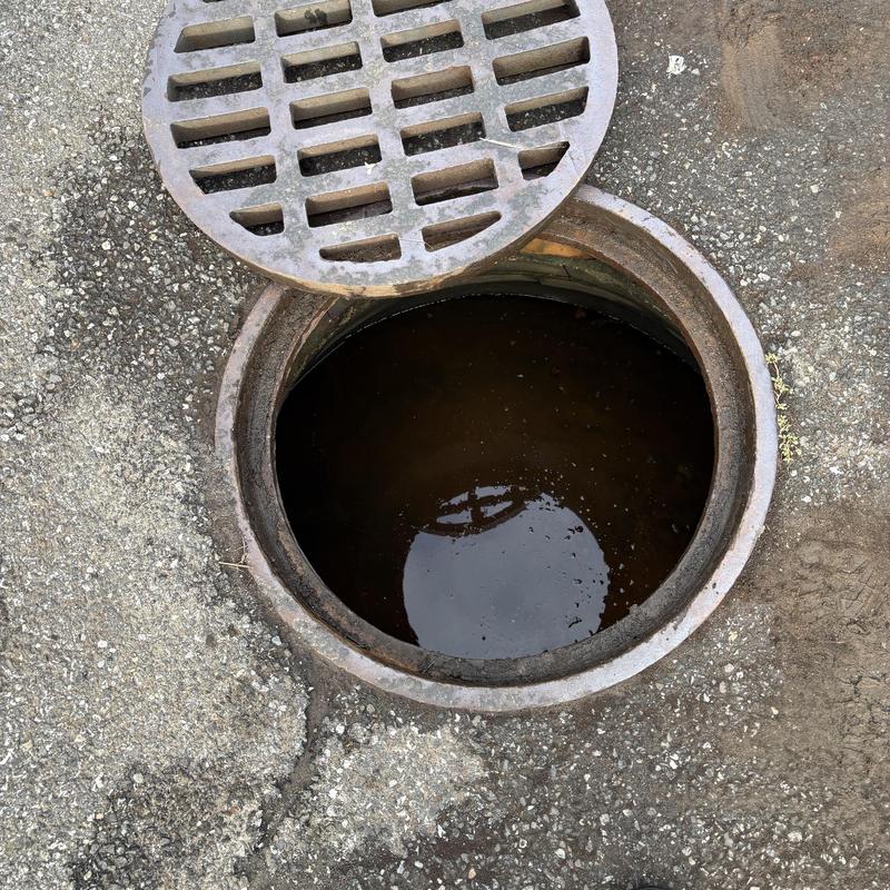 Storm drain manhole open on asphalt street Storm drain manhole open on asphalt street