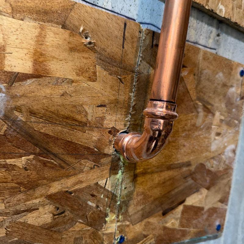 Copper piping elbow joint through wood wall section