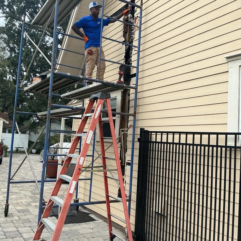 Exterior siding repair with scaffold and ladder setup Exterior siding repair with scaffold and ladder setup
