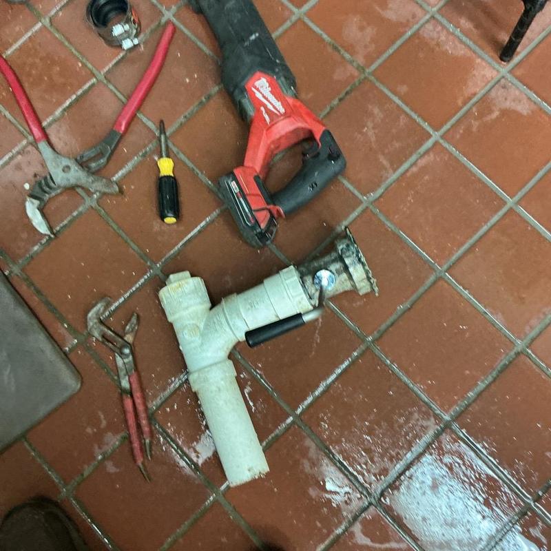 Commercial basket strainer with plumber tools on floor Commercial basket strainer with plumber tools on floor