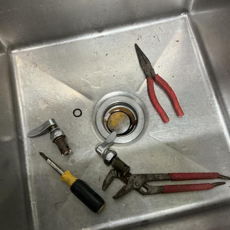 Three-compartment sink faucet stems with tools in sink Three-compartment sink faucet stems with tools in sink