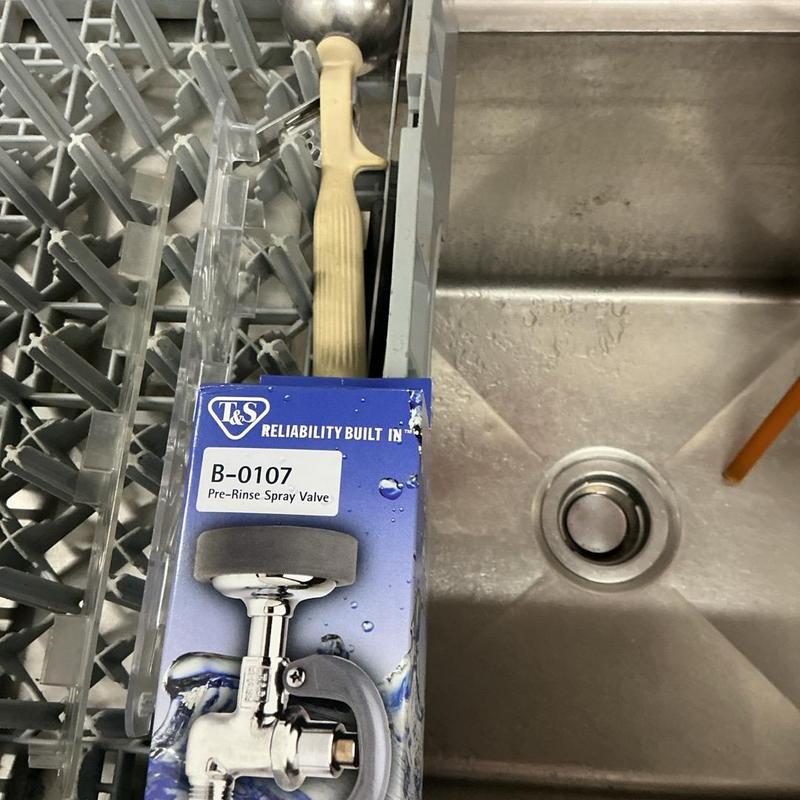 Pre-rinse spray valve box next to commercial sink drain Pre-rinse spray valve box next to commercial sink drain