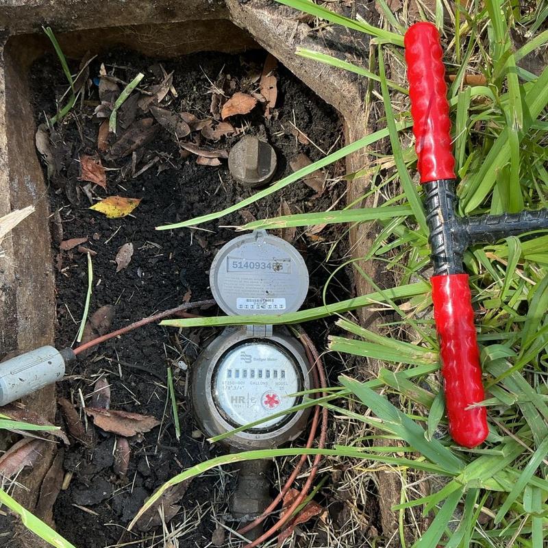 Water meter box with open lid and T-handle tool Water meter box with open lid and T-handle tool