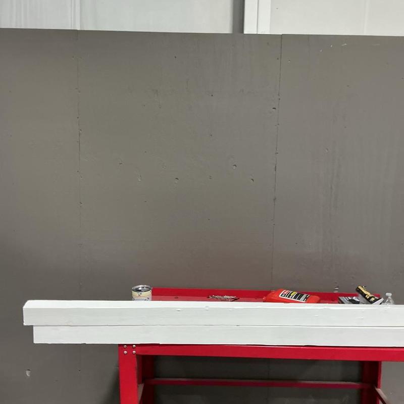 Work bench with wood planks and tools against gray wall Work bench with wood planks and tools against gray wall