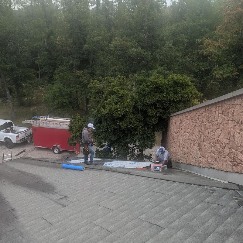 Mineral coated metal shingle roof with workers prepping