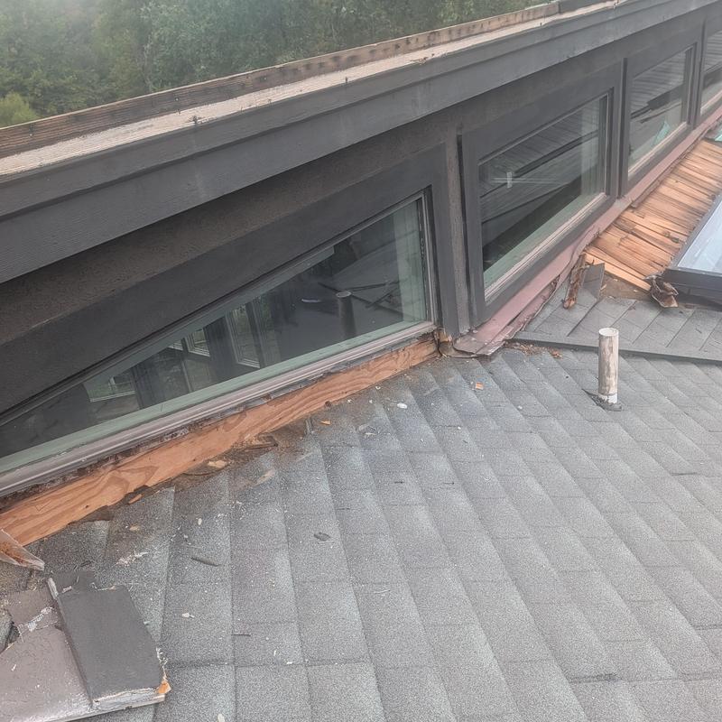 Skylight flashing damage with weathered roof shingles
