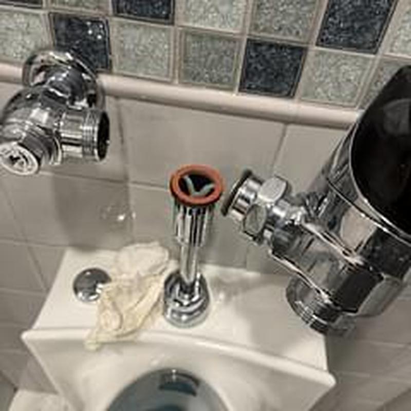 Flushometer valve assembly removal on restroom urinal