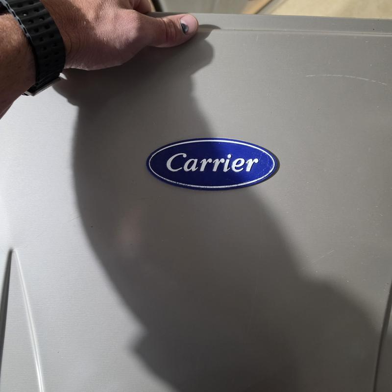 Carrier furnace maintenance with technician hand visible Carrier furnace maintenance with technician hand visible