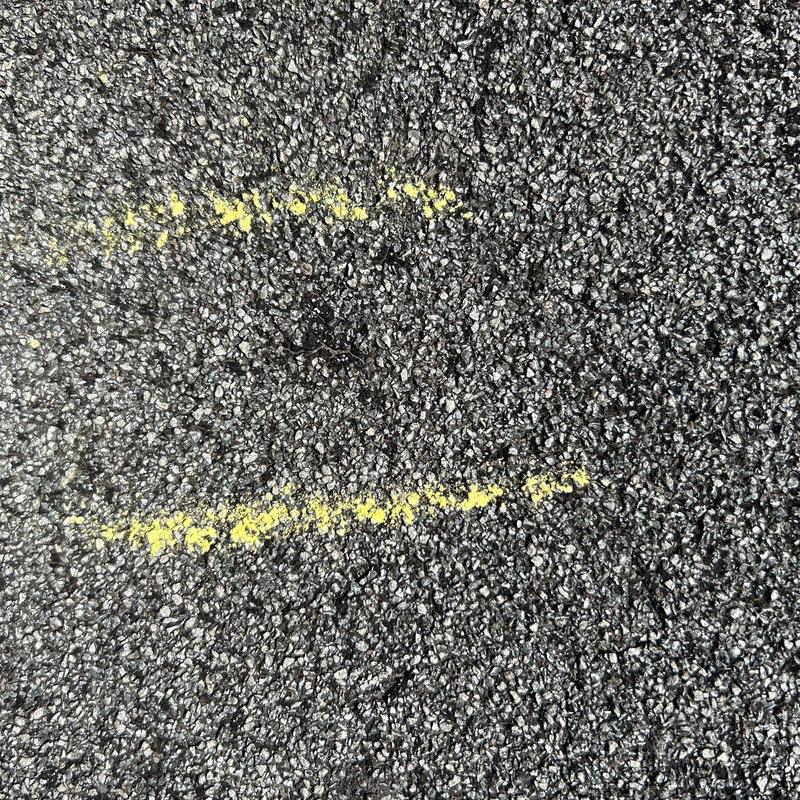 Roof shingles with hail damage marked in yellow paint