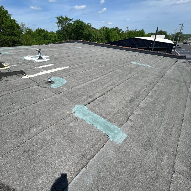 Flat roof with patch repairs and vent pipes