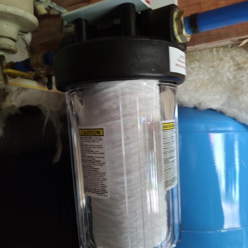 Whole house water filter installed with blue tank