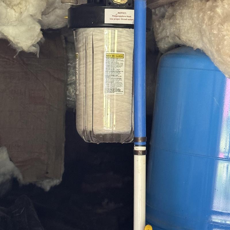 Whole house water filter installed with blue pipes
