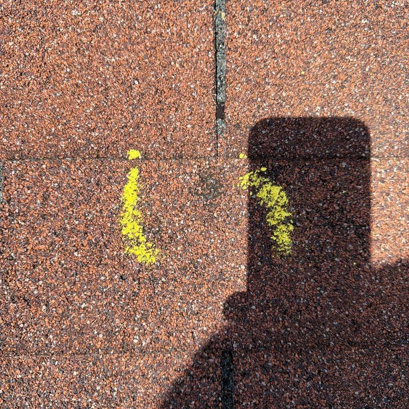 Asphalt shingle roof with hail damage marked in yellow