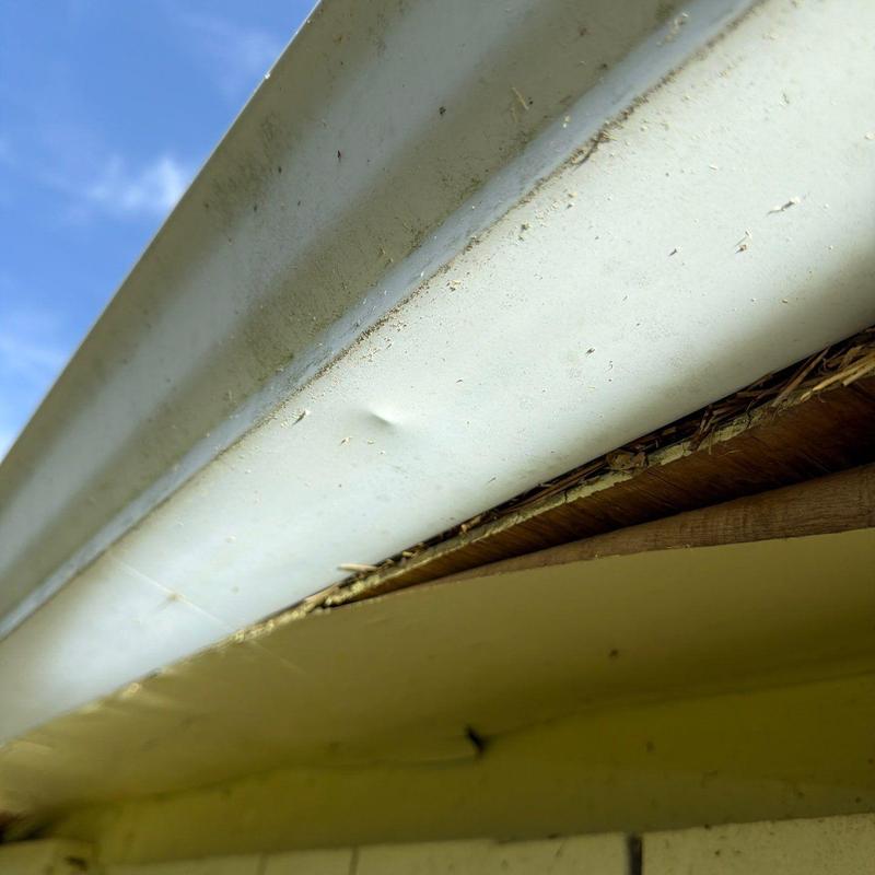 Gutter with dented section under eaves