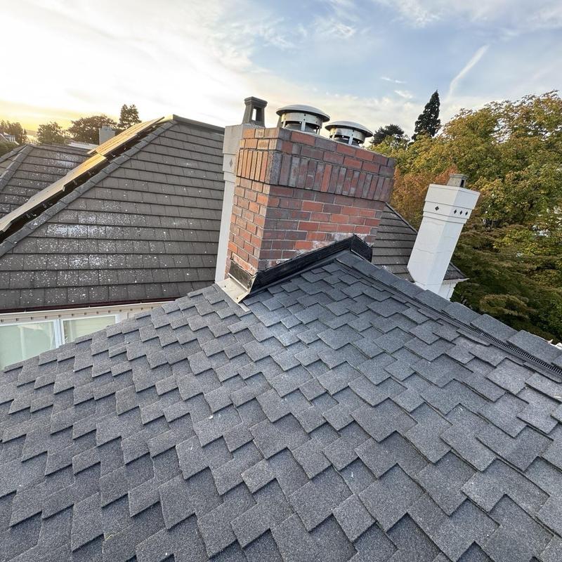Asphalt shingle roof with brick chimney flashing installation