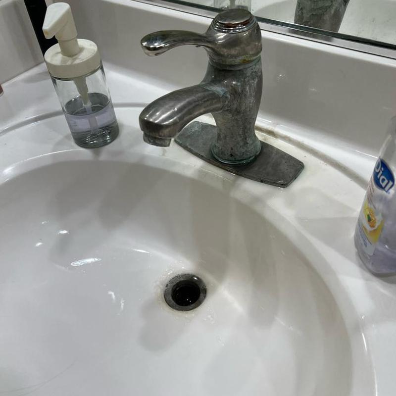 Bathroom sink faucet with soap dispenser on counter