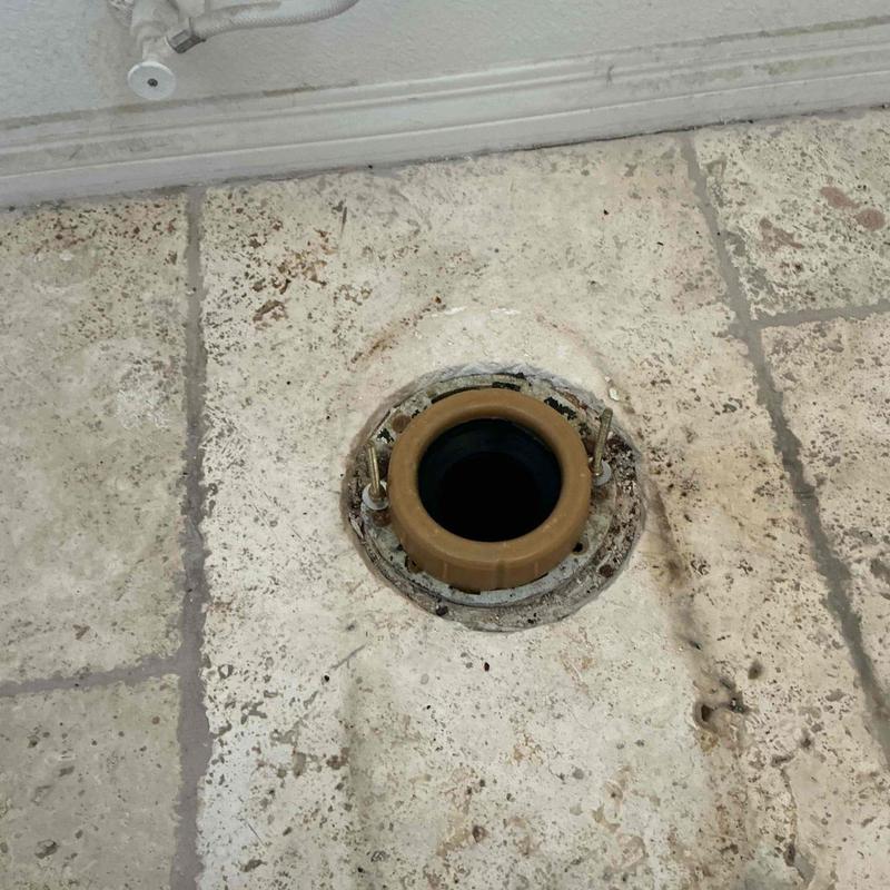 Toilet flange and mounting hardware on tile floor