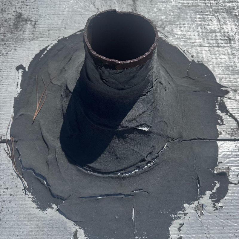 Low-slope roof pipe flashing with sealant repairs Low-slope roof pipe flashing with sealant repairs