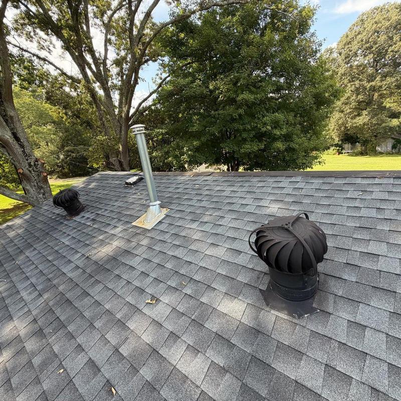 Pipe boots and vents on shingle roof with trees Pipe boots and vents on shingle roof with trees