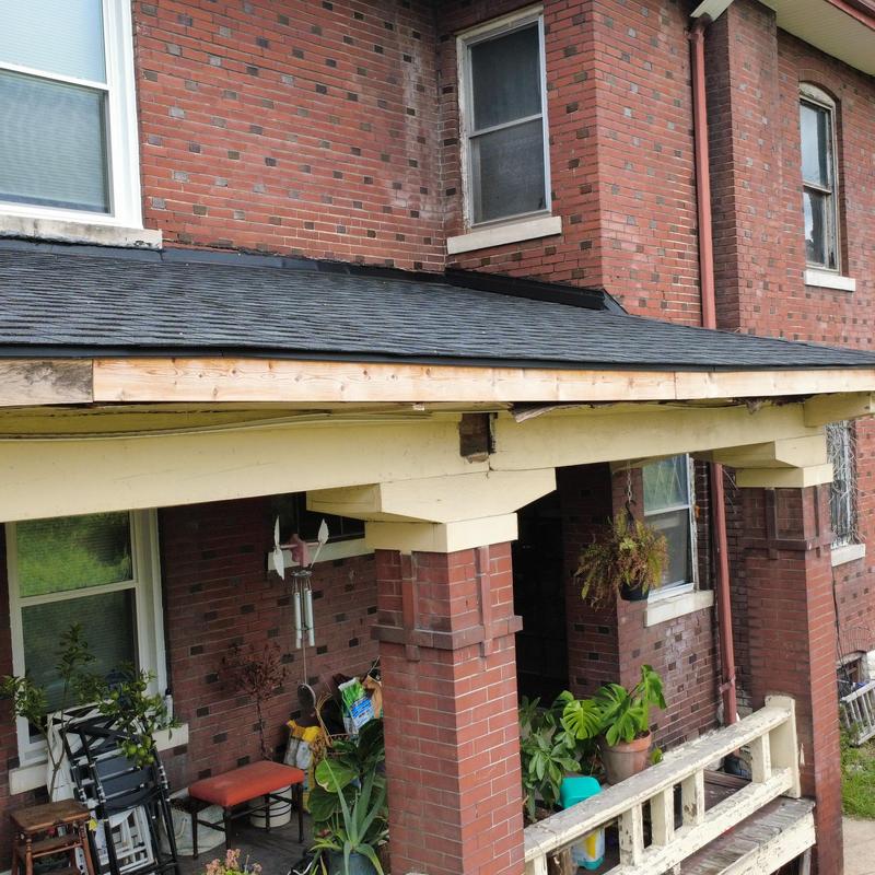 Porch roof fascia wood repair on brick home exterior