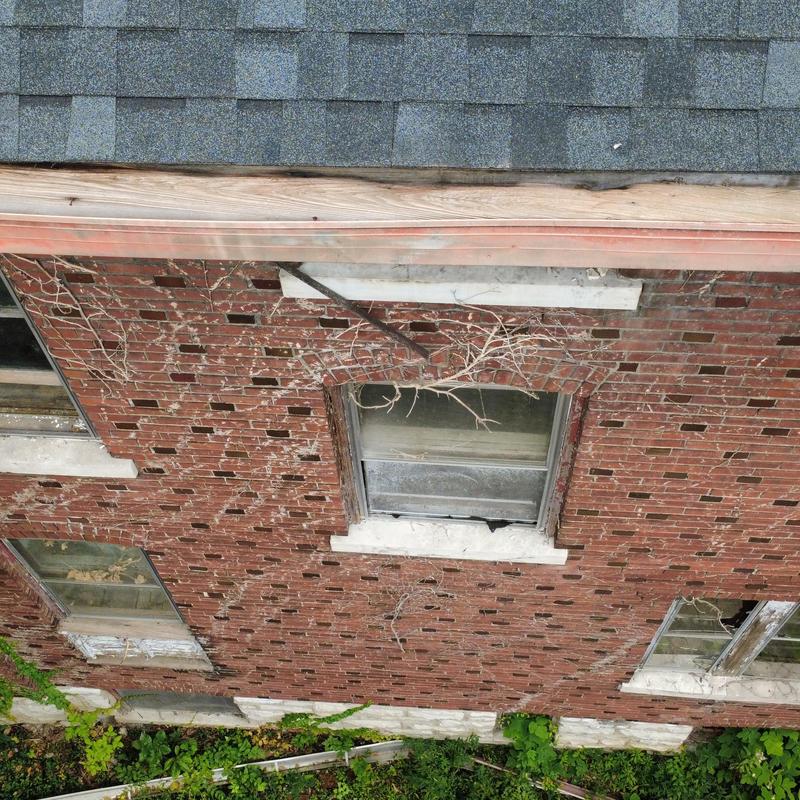 Brick wall with damaged and boarded windows