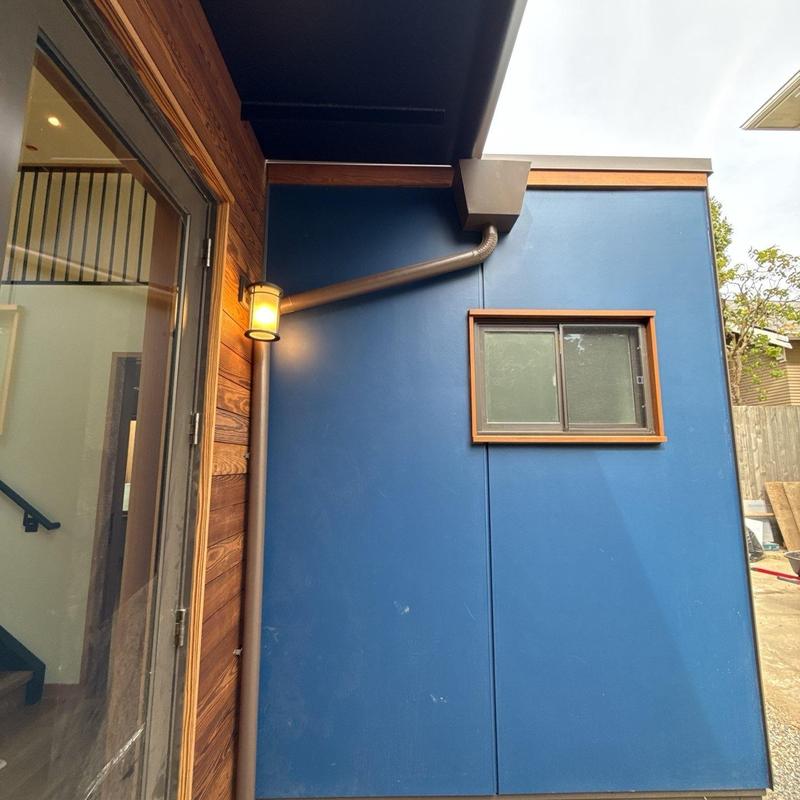 Scupper and downspout on blue exterior wall