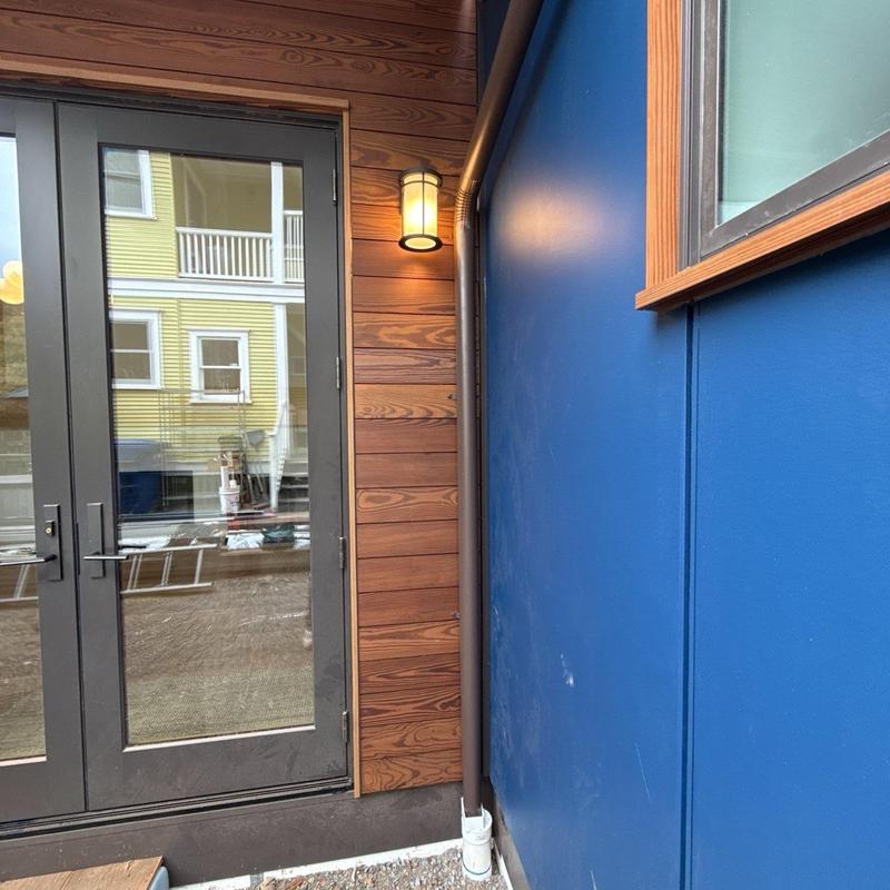 Downspout and scupper installation on exterior wall