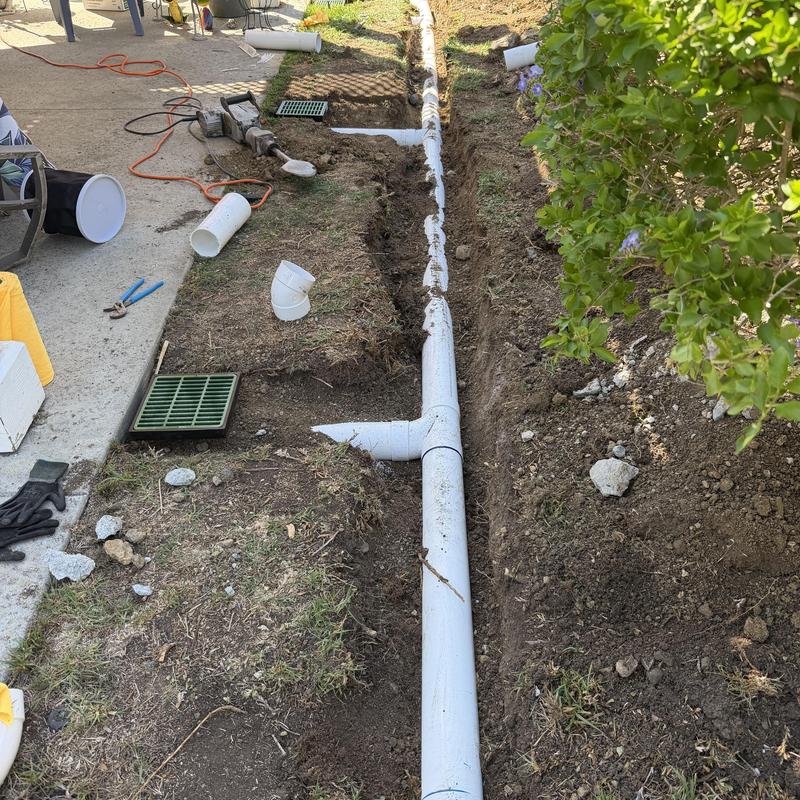 Storm drain PVC piping installation in backyard trench Storm drain PVC piping installation in backyard trench
