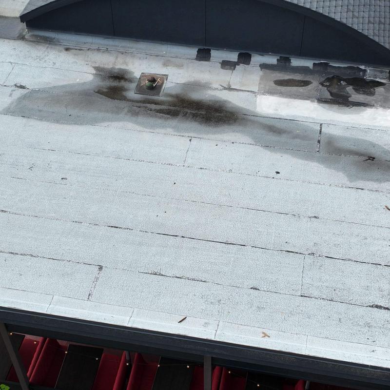 Flat commercial roof membrane with water staining and wear Flat commercial roof membrane with water staining and wear