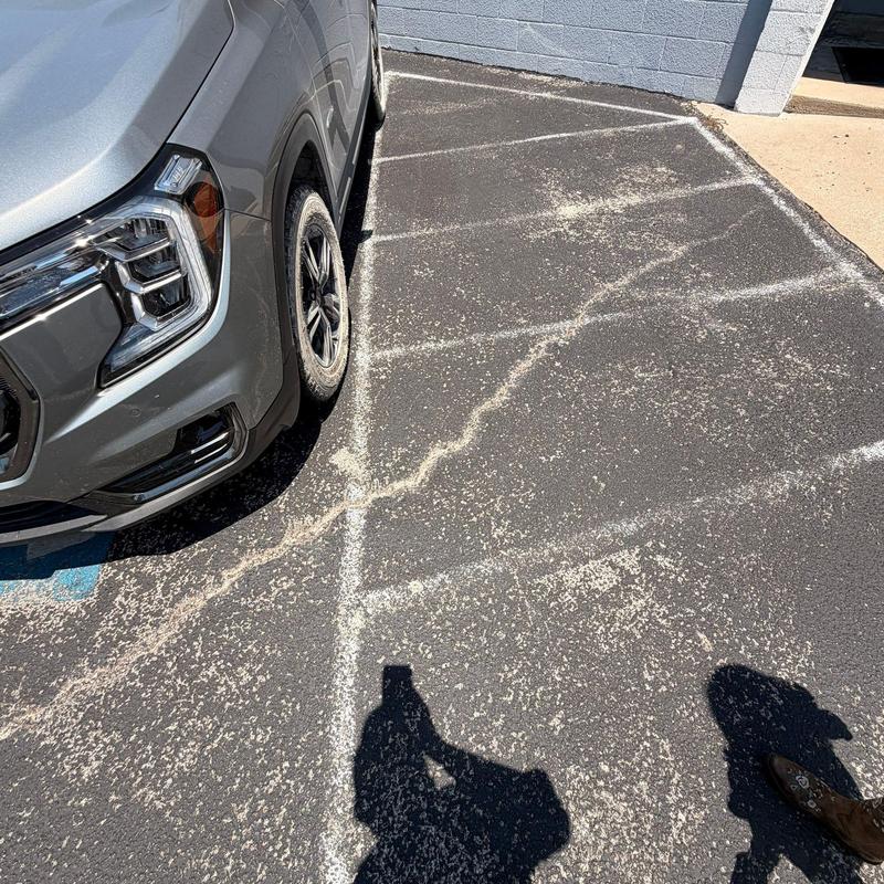 Asphalt parking lot crack overview with vehicle nearby Asphalt parking lot crack overview with vehicle nearby