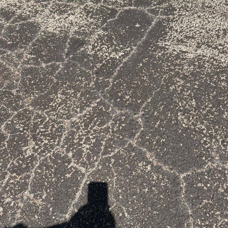 Asphalt roof surface with hail damage and cracking Asphalt roof surface with hail damage and cracking
