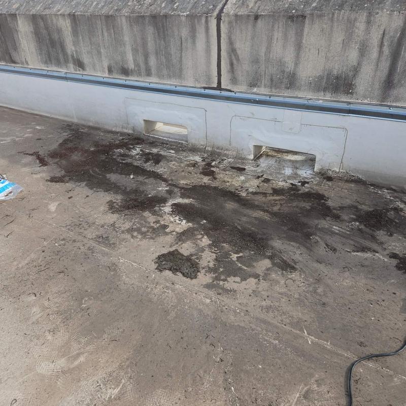 Roofing membrane damage and debris near drain flashing Roofing membrane damage and debris near drain flashing