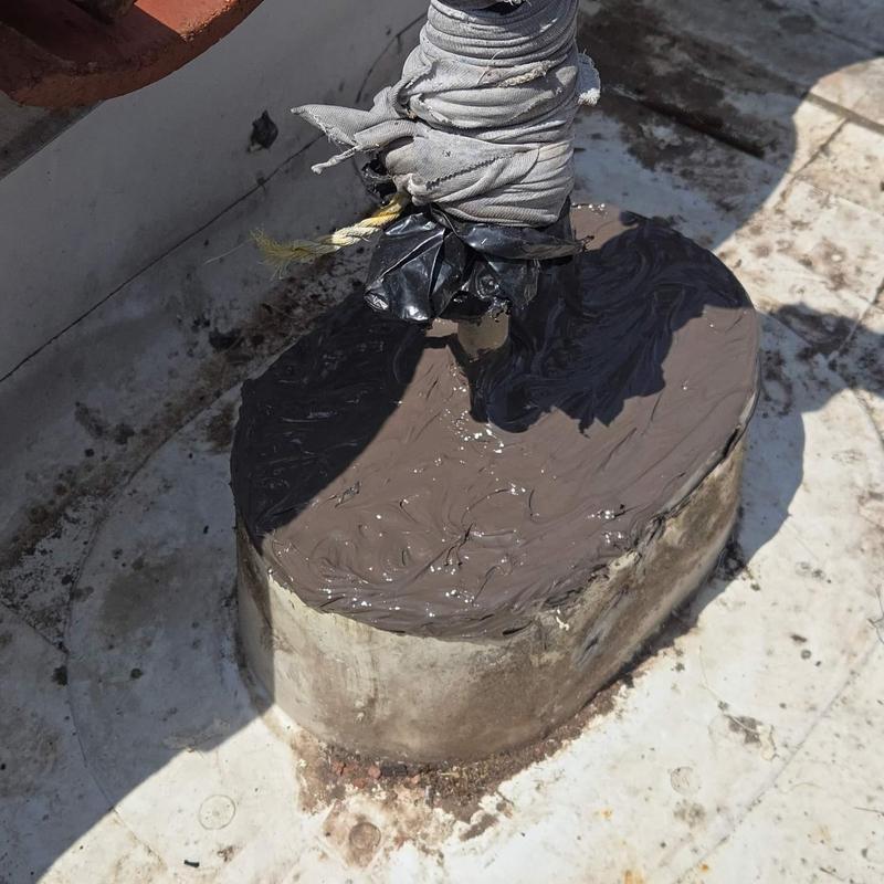 Roof pipe flashing with sealant application on flat roof Roof pipe flashing with sealant application on flat roof