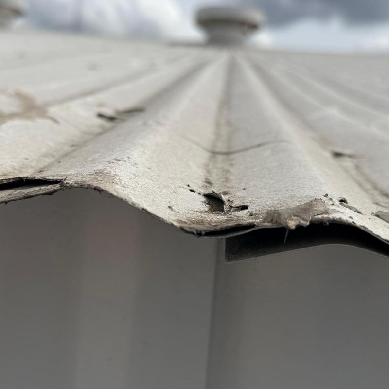 Corrugated metal roof edge with hail damage close-up Corrugated metal roof edge with hail damage close-up