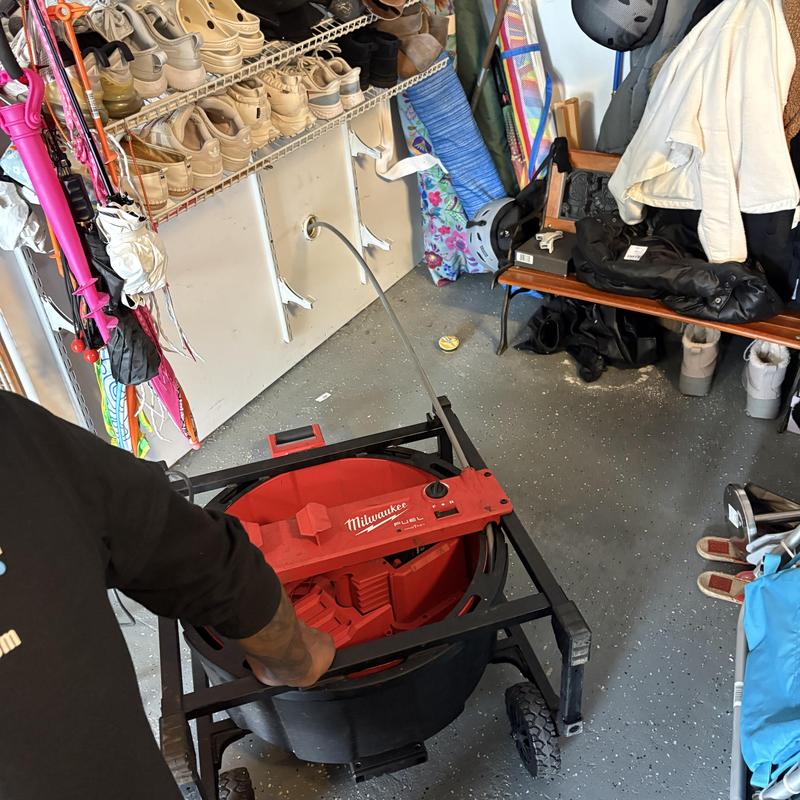 Main line sewer drain cleaning machine in residential garage Main line sewer drain cleaning machine in residential garage