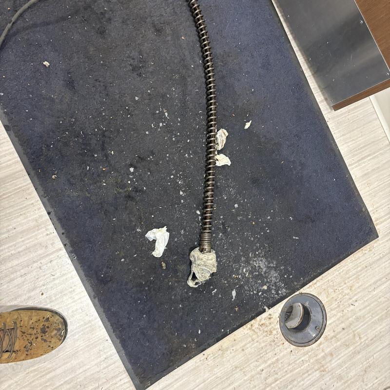 Main sewer line snake with debris on mat Main sewer line snake with debris on mat