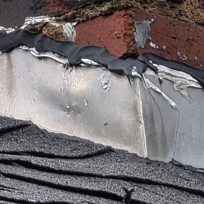 Chimney metal flashing with sealant on shingle roof Chimney metal flashing with sealant on shingle roof
