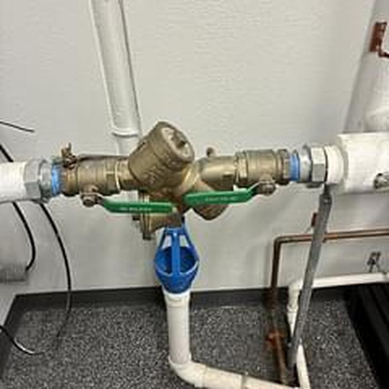 Backflow prevention valve with green handles and piping