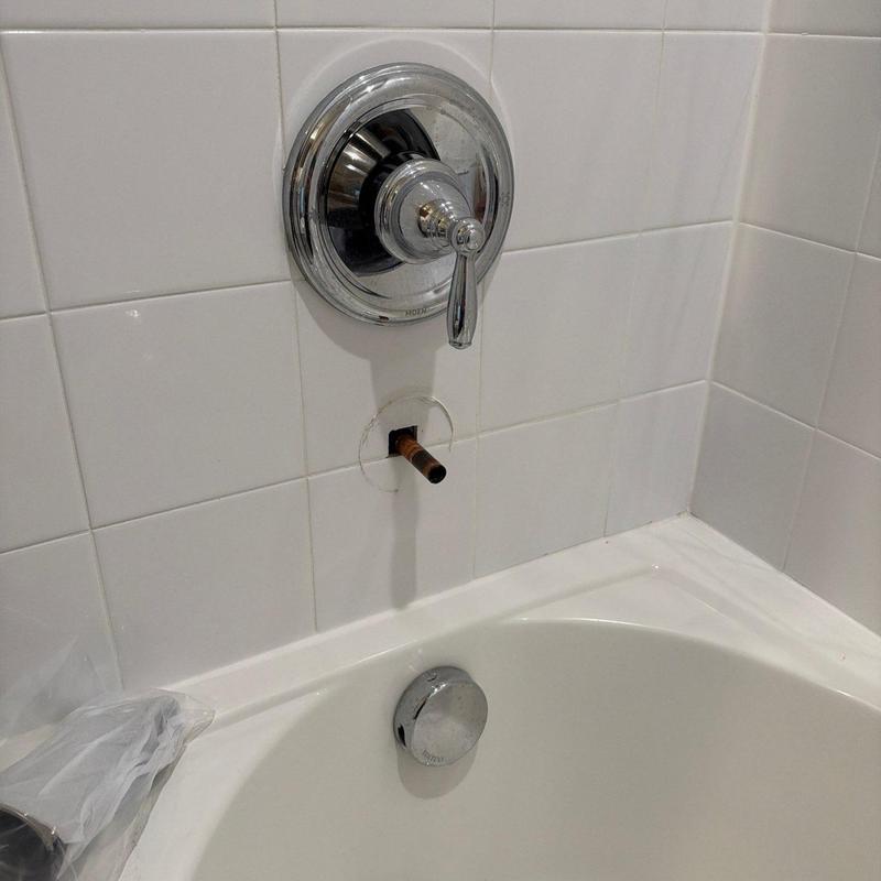 Tub spout extension pipe exposed in tiled bathtub wall