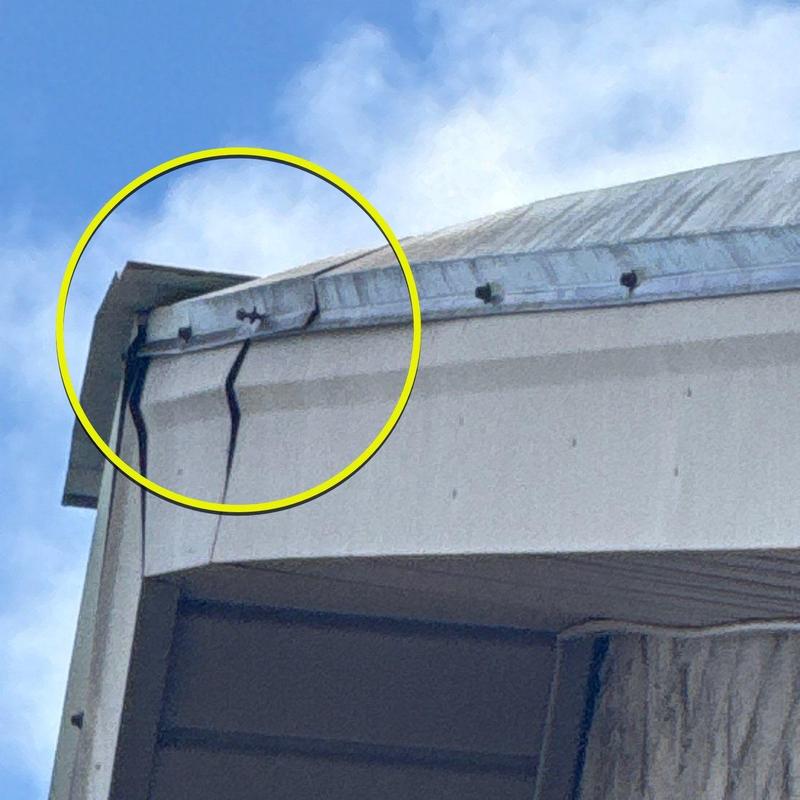 Metal roof edge damage with visible tears and dents
