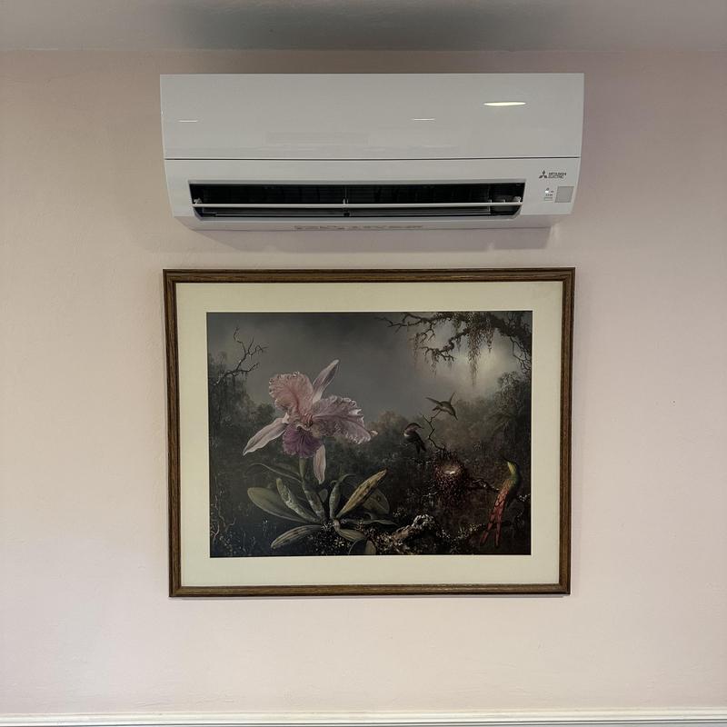 Mini split air conditioner above framed artwork wall