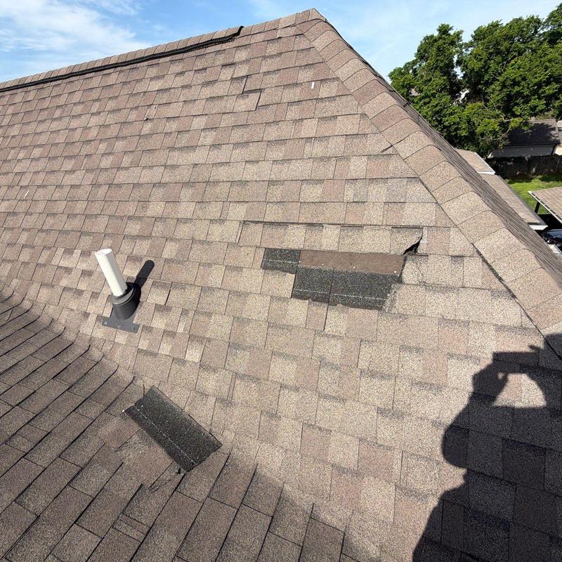 Roof shingles with hail damage and missing patches