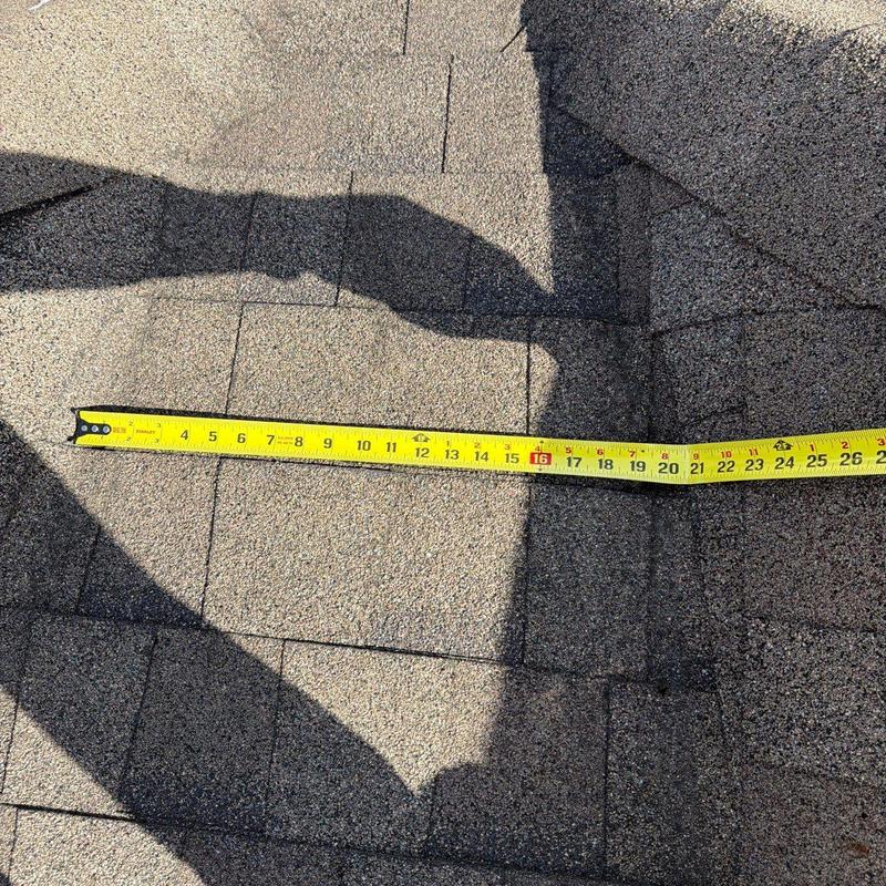 Roof shingles with tape measure for hail damage inspection