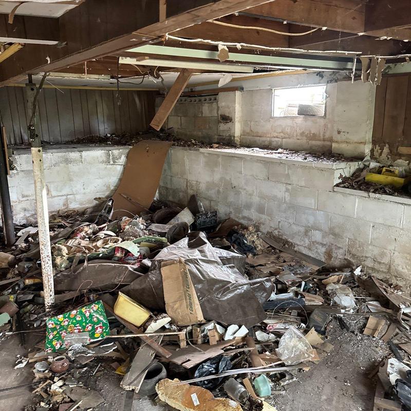 Basement foundation walls with debris and damage