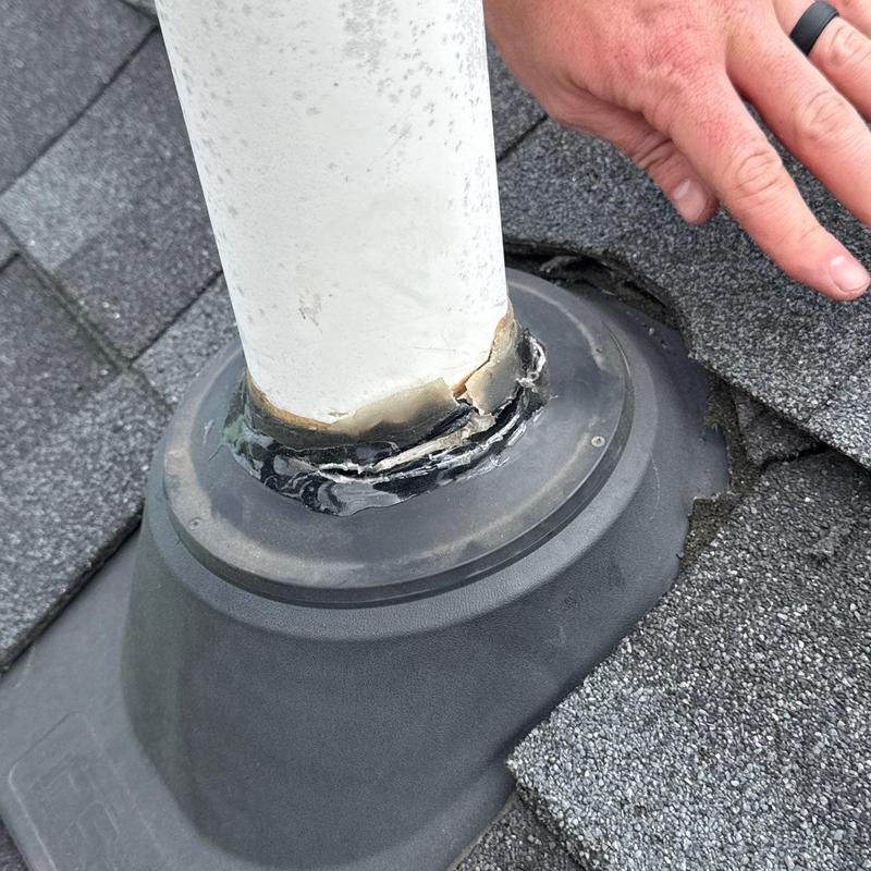 Roof pipe flashing with cracked sealant on shingle roof